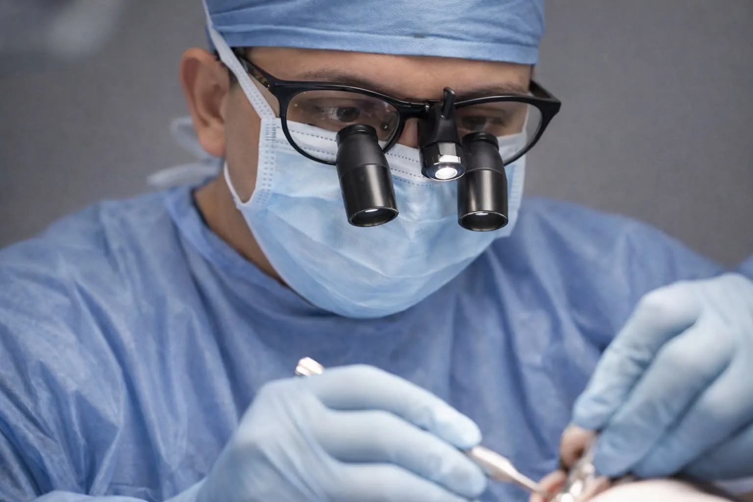 Dr Ridhwan Ahmed performing a dental procedure using surgical loupes and magnification